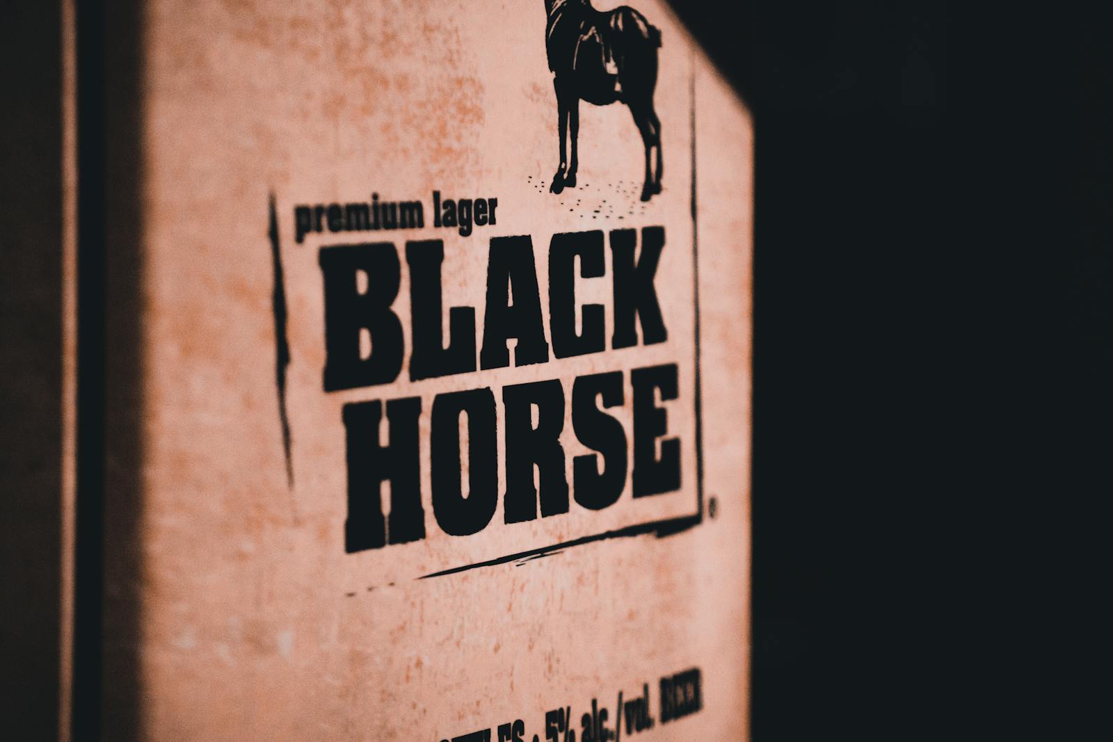 Close-up photo of Black Horse lager packaging with prominent text.